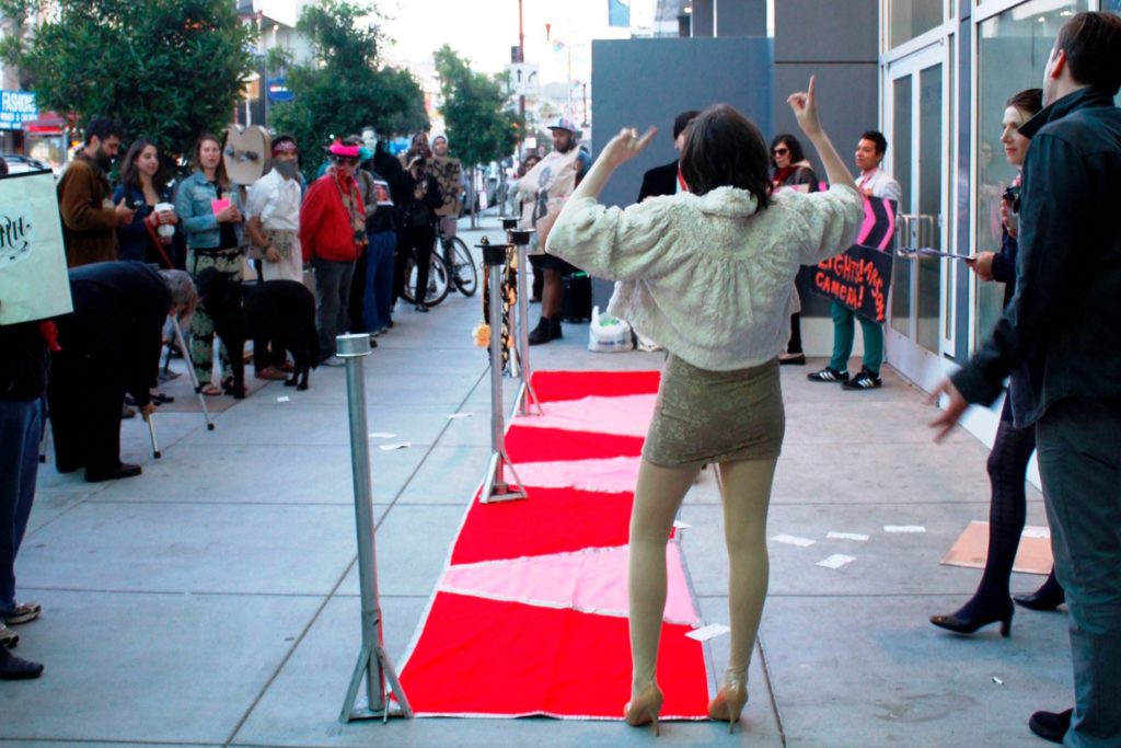 people gather to walk the red carpet step-and-repeat on the mission sidewalk directly in front of the new vida luxury condo complex on mission at 22nd street