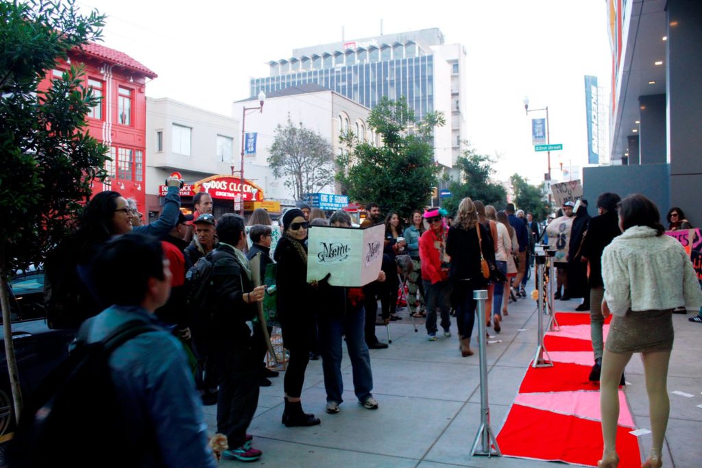 people gather to watch celebrities take to the red carpet step-and-repeat on the sidewalk in front of the vida luxury condo complex at mission and 22nd streets
