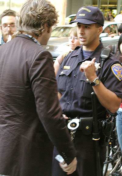 a police officer talking to some person in a suit