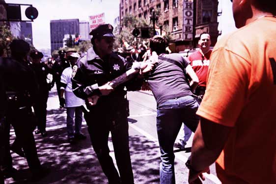 police and newsom parade volunteer removing person from parade route
