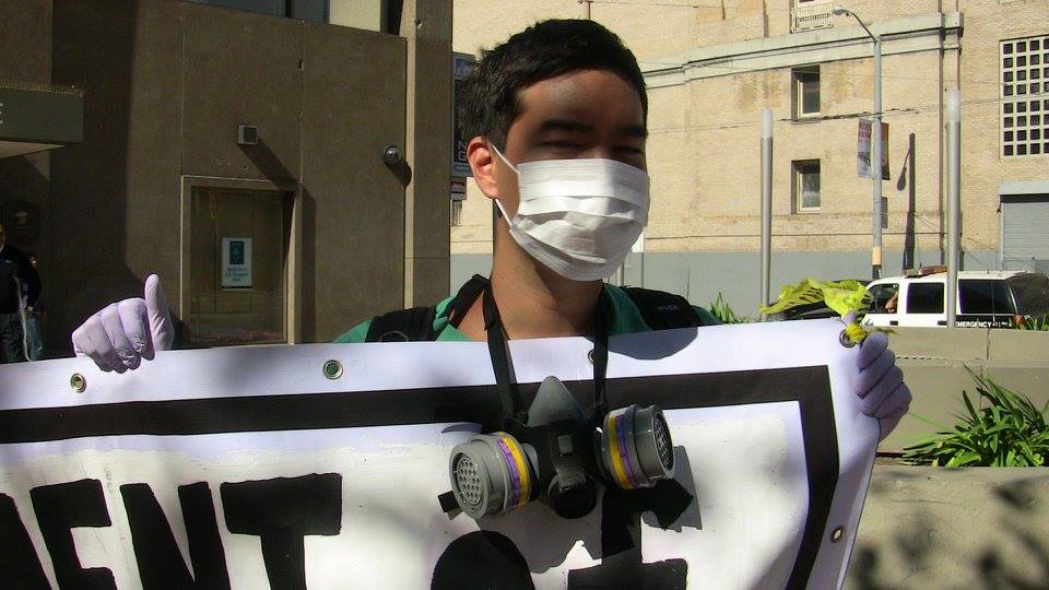 person in a face mask holding a banner