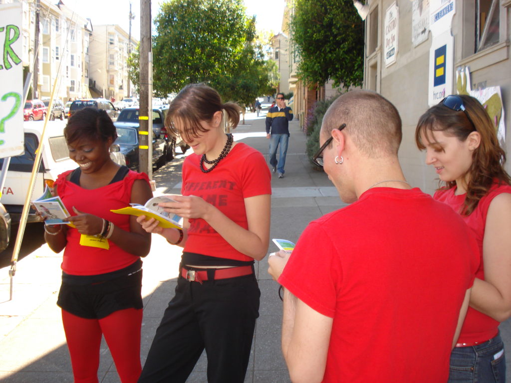 a group of radical cheerleaders scandalized by the naked corporate avarice on display in the hrc.org store official corporate ally buyer's guide while milling about at the corner of 19th and castro at the original HRC.org store location 