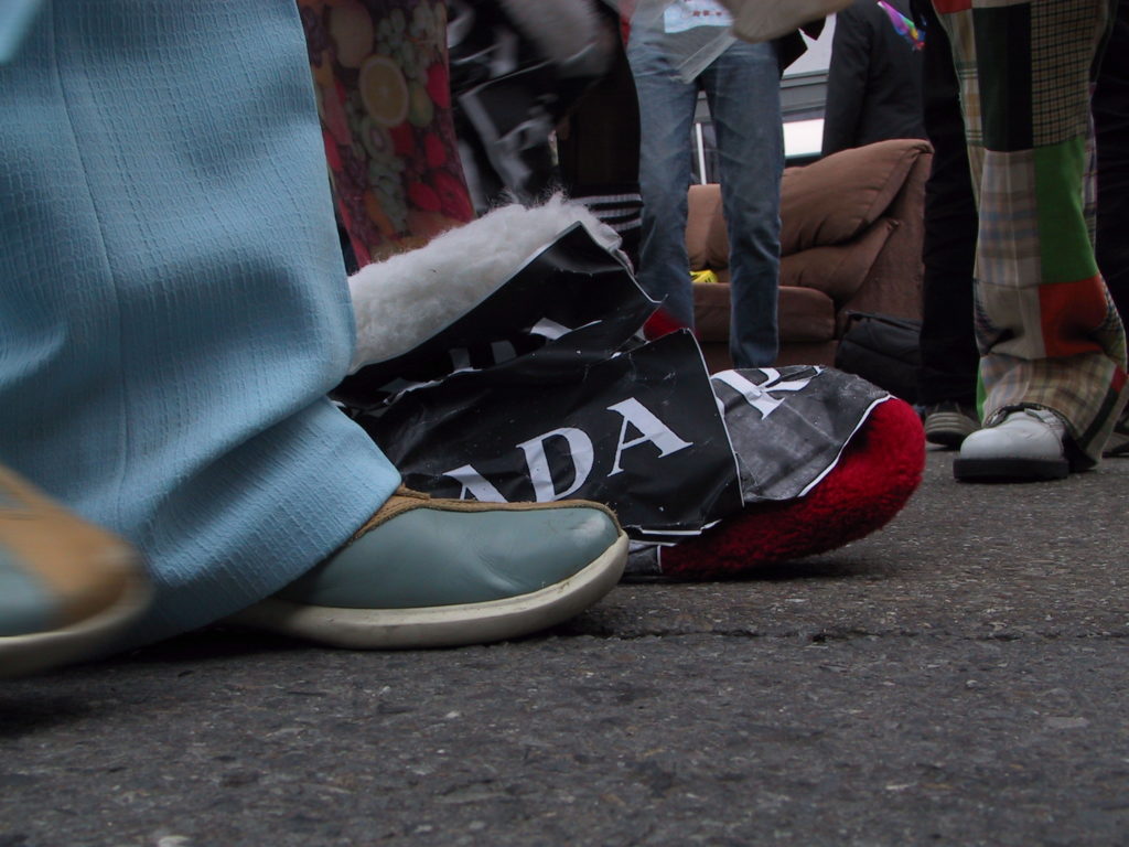 detail of reveler's footwear as the crowd fills castro street with a couch on the asphalt in the background