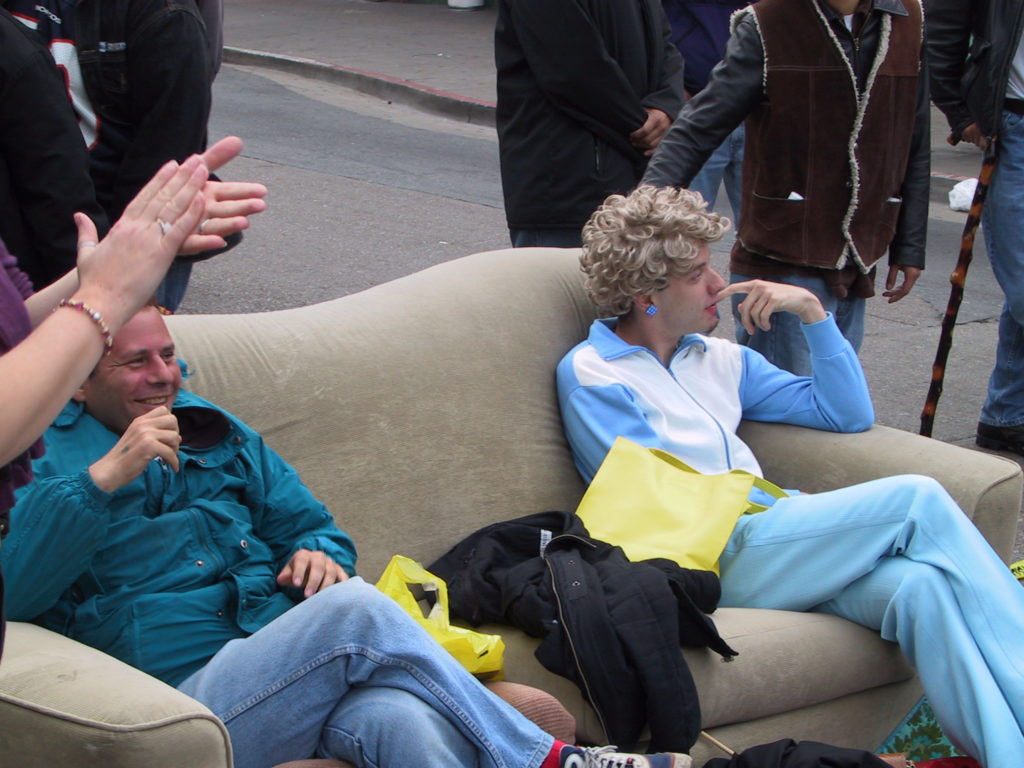 a couch has been drug out into the middle of castro street and awards ceremony attendees relax as the dance party starts up