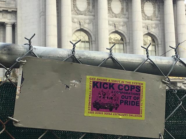 gay shame cops out of pride sticker stuck to a chainlink fence in front of san francisco city hall