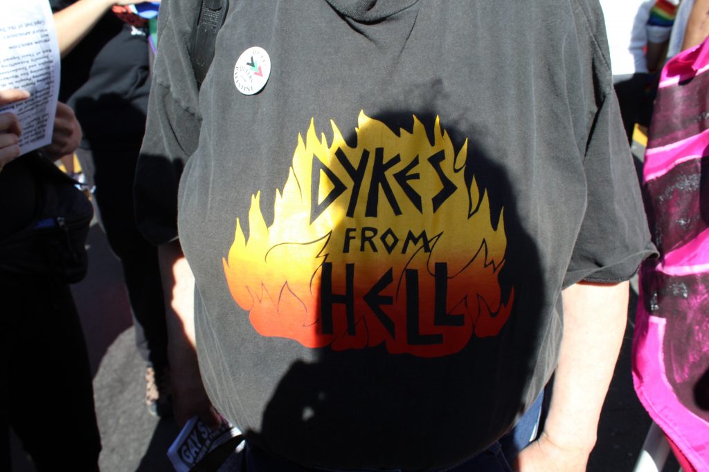someone wearing a tshirt that reads "dykes from hell"